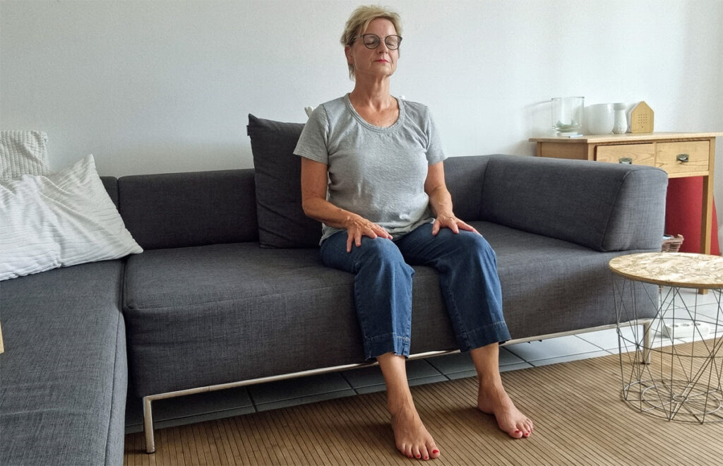 Meditieren in aufrechter Sitzhaltung auf dem Sofa